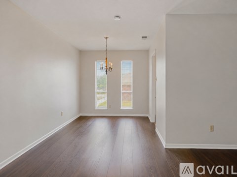 A room with wooden floors and a chandelier.