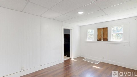 A room with white walls and wooden flooring is available for rent.
