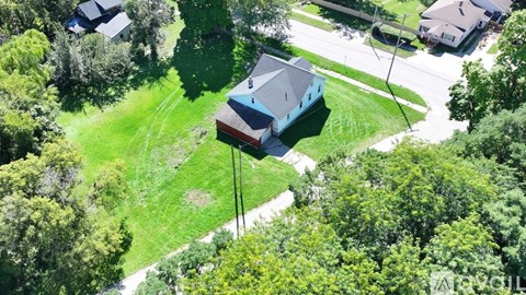 A house with a red roof is surrounded by trees.