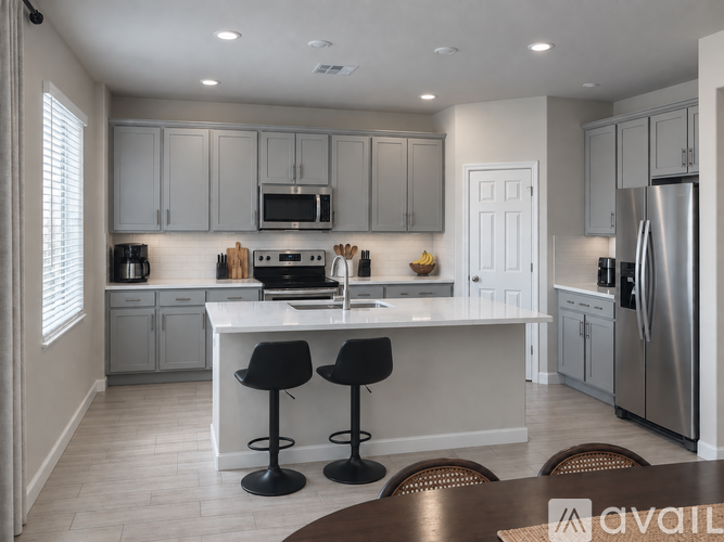 A modern kitchen with a white island and stainless steel appliances.