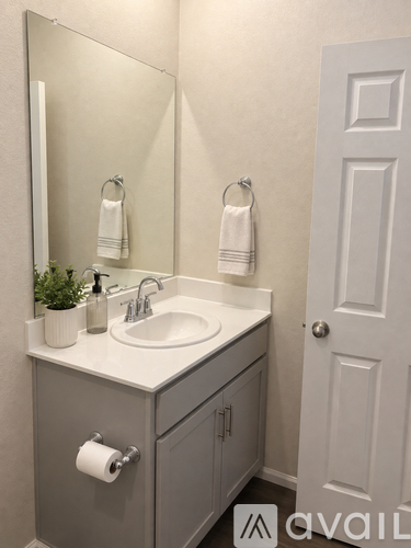 A bathroom with a sink, mirror, and towel rack.