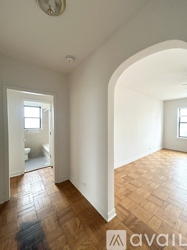 A room with wooden flooring and white walls.