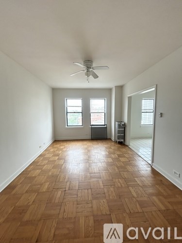 A room with wooden flooring and a ceiling fan.