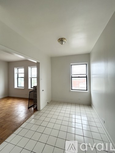 A room with a tiled floor and two windows.