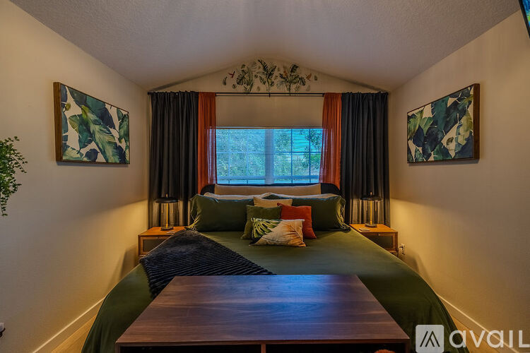 A bedroom with a bed and two artworks on the wall.