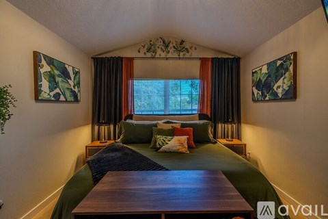 A bedroom with a bed and two artworks on the wall.