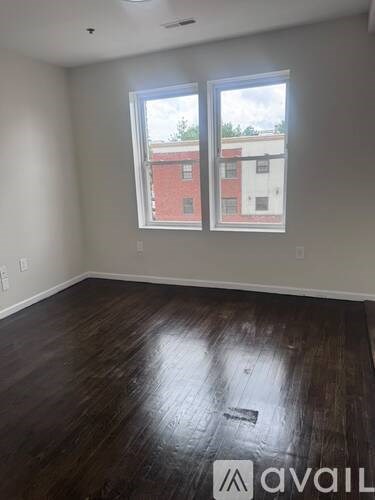 A room with a large window and wooden flooring.