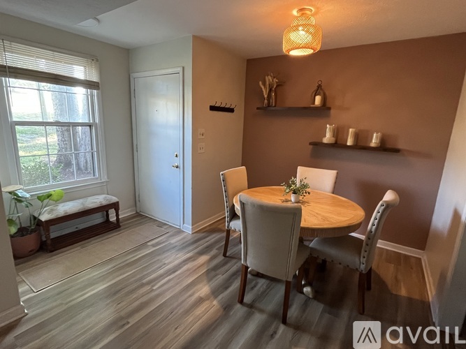 A dining room with a round table and chairs.