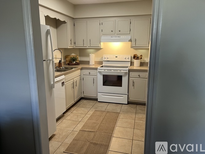 A kitchen with white appliances and cabinets.