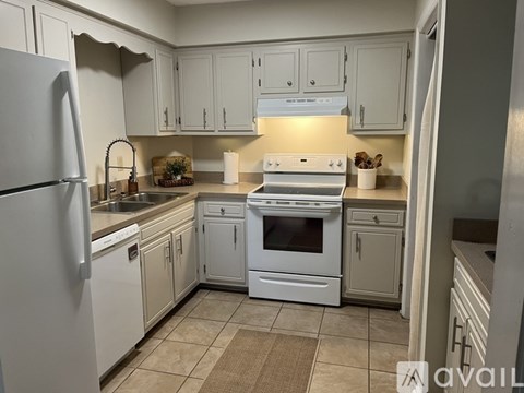 A kitchen with white appliances and cabinets.