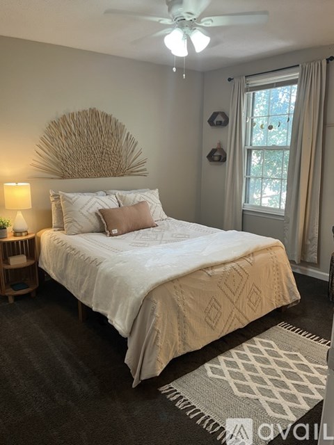A bedroom with a large bed and a ceiling fan.