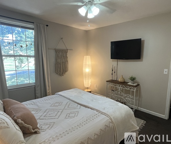 A bedroom with a large bed and a flat screen TV mounted on the wall.