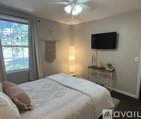 A bedroom with a large bed and a flat screen TV mounted on the wall.