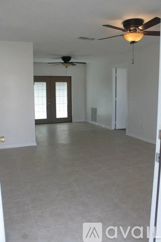 A room with a ceiling fan and tile flooring.
