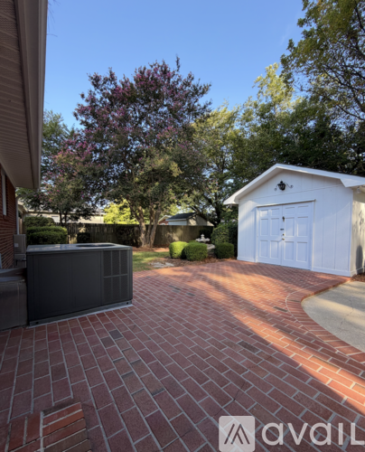 A brick walkway leads to a white garage.