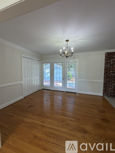 A room with wooden floors and a chandelier.