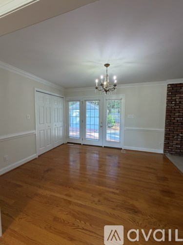 A room with wooden floors and a chandelier.