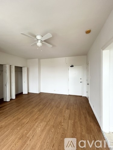 A room with wooden floors and a ceiling fan.
