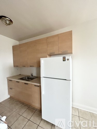 A kitchen with a white fridge and wooden cabinets.