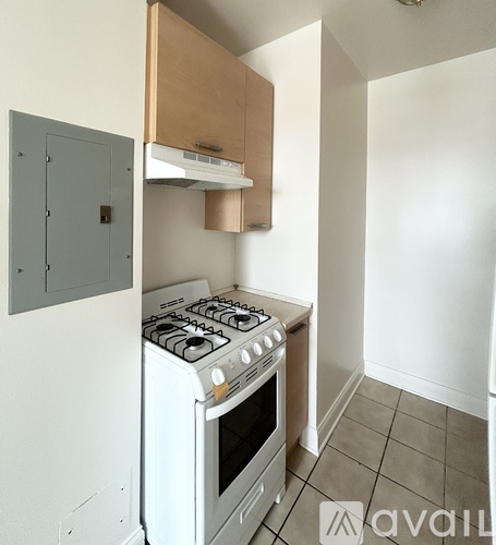 A small kitchen with a white stove and a grey cabinet.