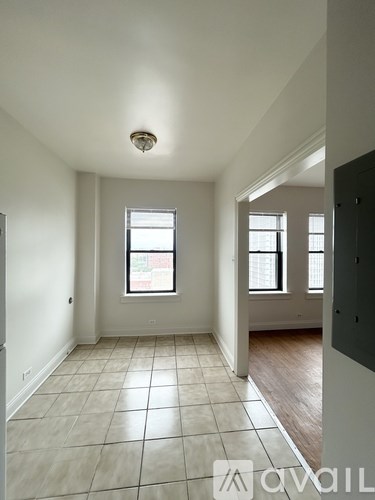 A room with a window and tiled flooring.