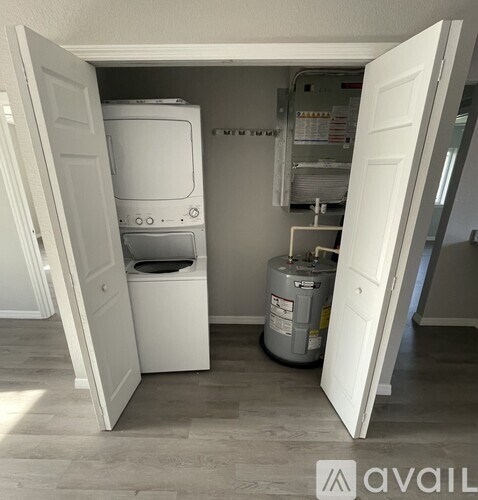 A white washing machine is in a small laundry room.