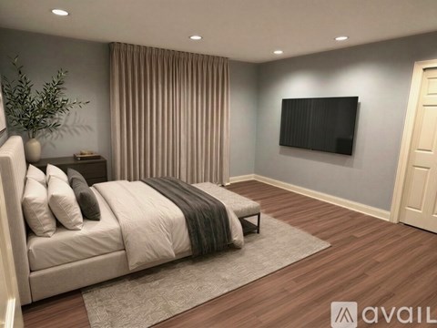 A modern bedroom with a large bed and a flat screen TV mounted on the wall.