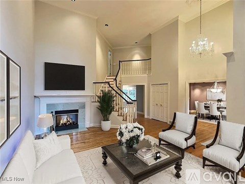 A living room with a fireplace and a television on the wall.