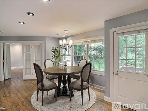 A dining room with a round table and chairs.