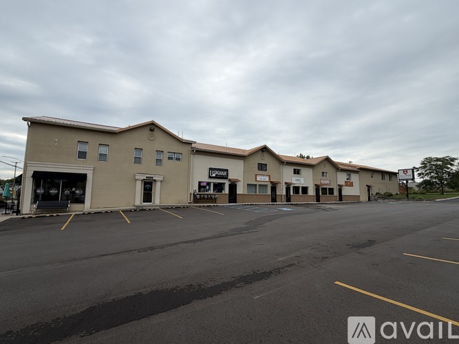 A parking lot in front of a building with the word "AVAIL" on it.