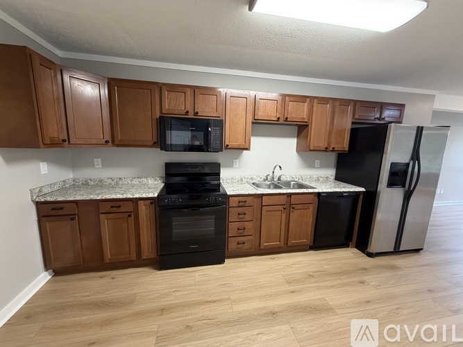 A kitchen with wooden cabinets and a granite countertop.