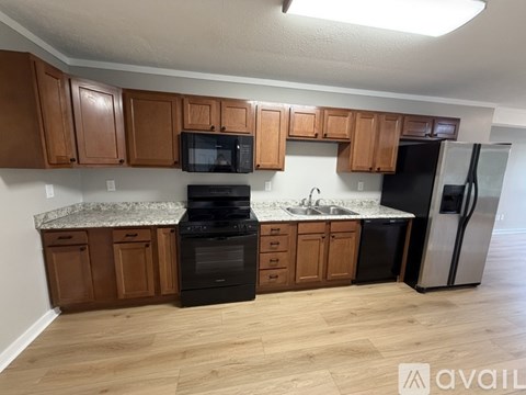 A kitchen with wooden cabinets and a granite countertop.