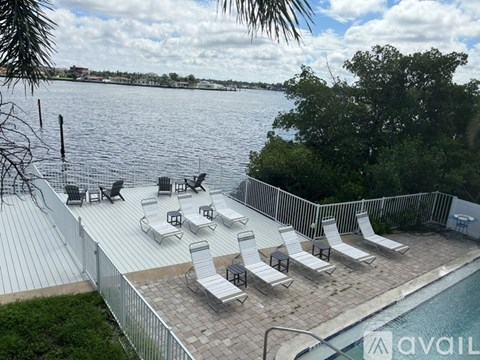 A poolside area with chairs and a view of the water.