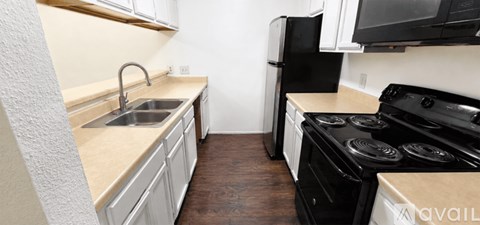 A kitchen with black appliances and white cabinets.