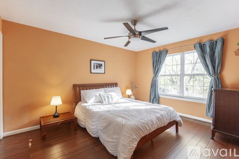 A bedroom with a bed, nightstand, and window.