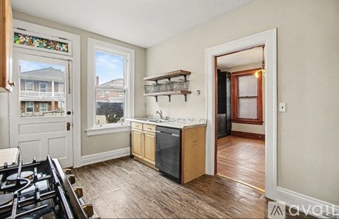 A kitchen with a stove top oven and a window overlooking a street.
