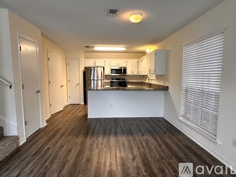 A kitchen with a refrigerator, microwave, and oven.