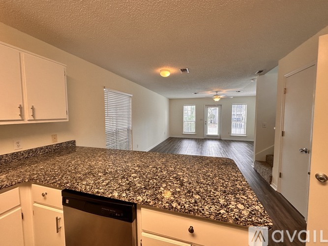 A kitchen with a granite countertop and white cabinets.