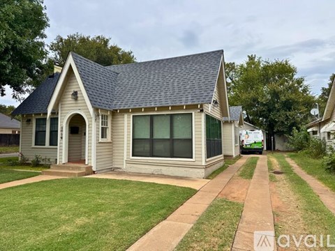 A house with a grey roof and a white fence.