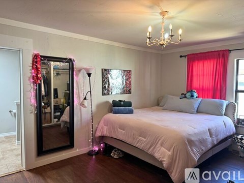 A bedroom with a large bed and a chandelier.
