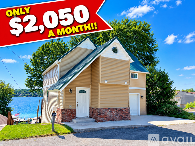A house with a sign that says "ONLY $2,050 A MONTH!!!" in front of it.