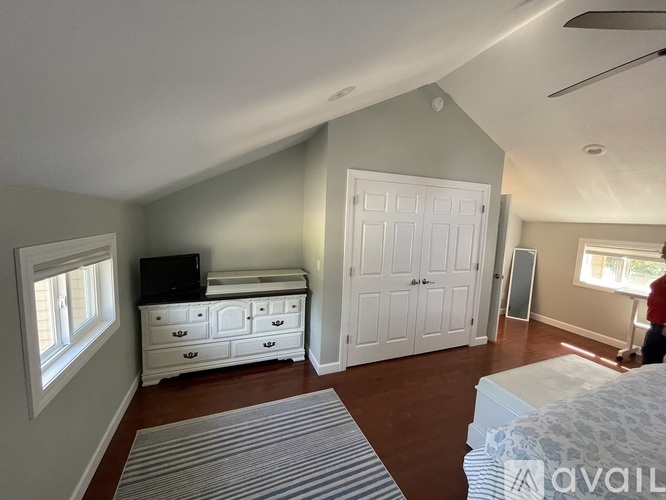 A bedroom with a white dresser and a window.