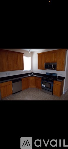A kitchen with wooden cabinets and black countertops.