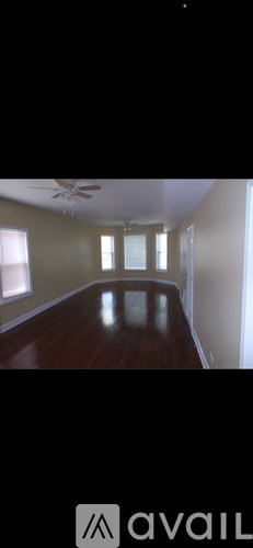 A room with wooden floors and a ceiling fan.