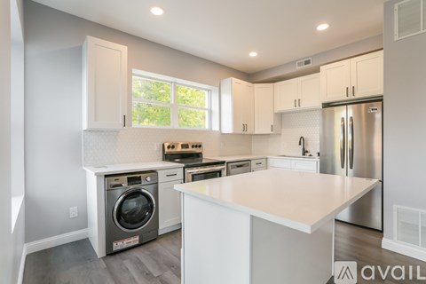 A modern kitchen with a washing machine built into the cabinetry.