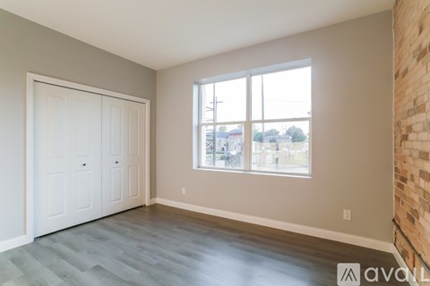 A room with a white door and a window with a view of the outside.