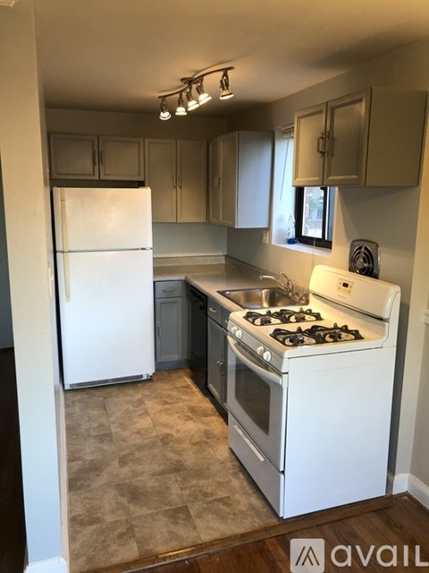 A kitchen with a white stove and a white refrigerator.