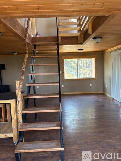 A wooden staircase leads up to a loft area in a house.