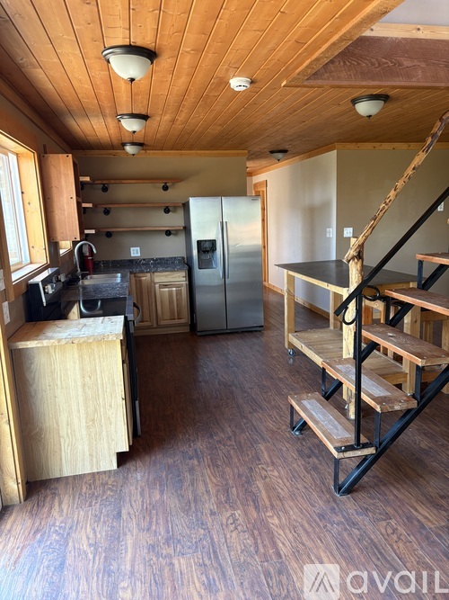 A kitchen with wooden floors and a staircase.