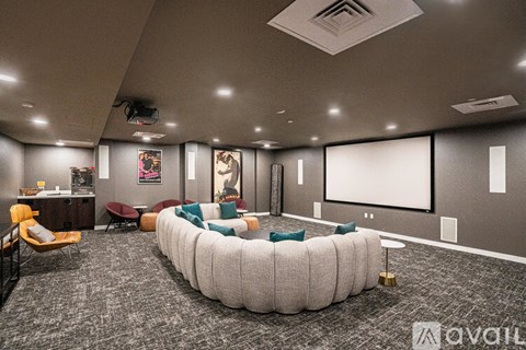A modern conference room with a large screen and comfortable seating.